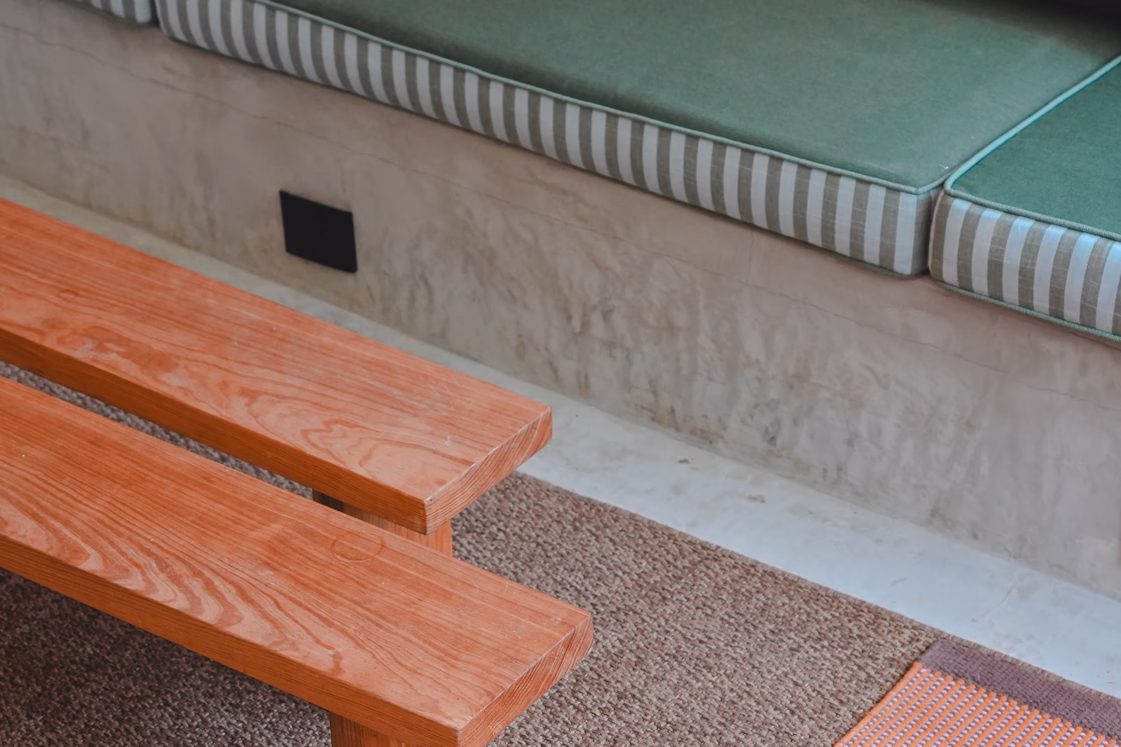Boutique hotel interior with a wooden bench and green built-in seating